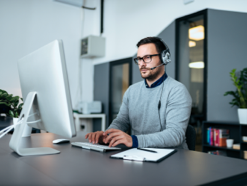 Man in a headset at a large monitor