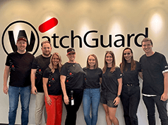 WatchGuard employees in front of the new WatchGuard logo sign at headquarters